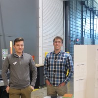 Two students standing next to a third karaoke project.